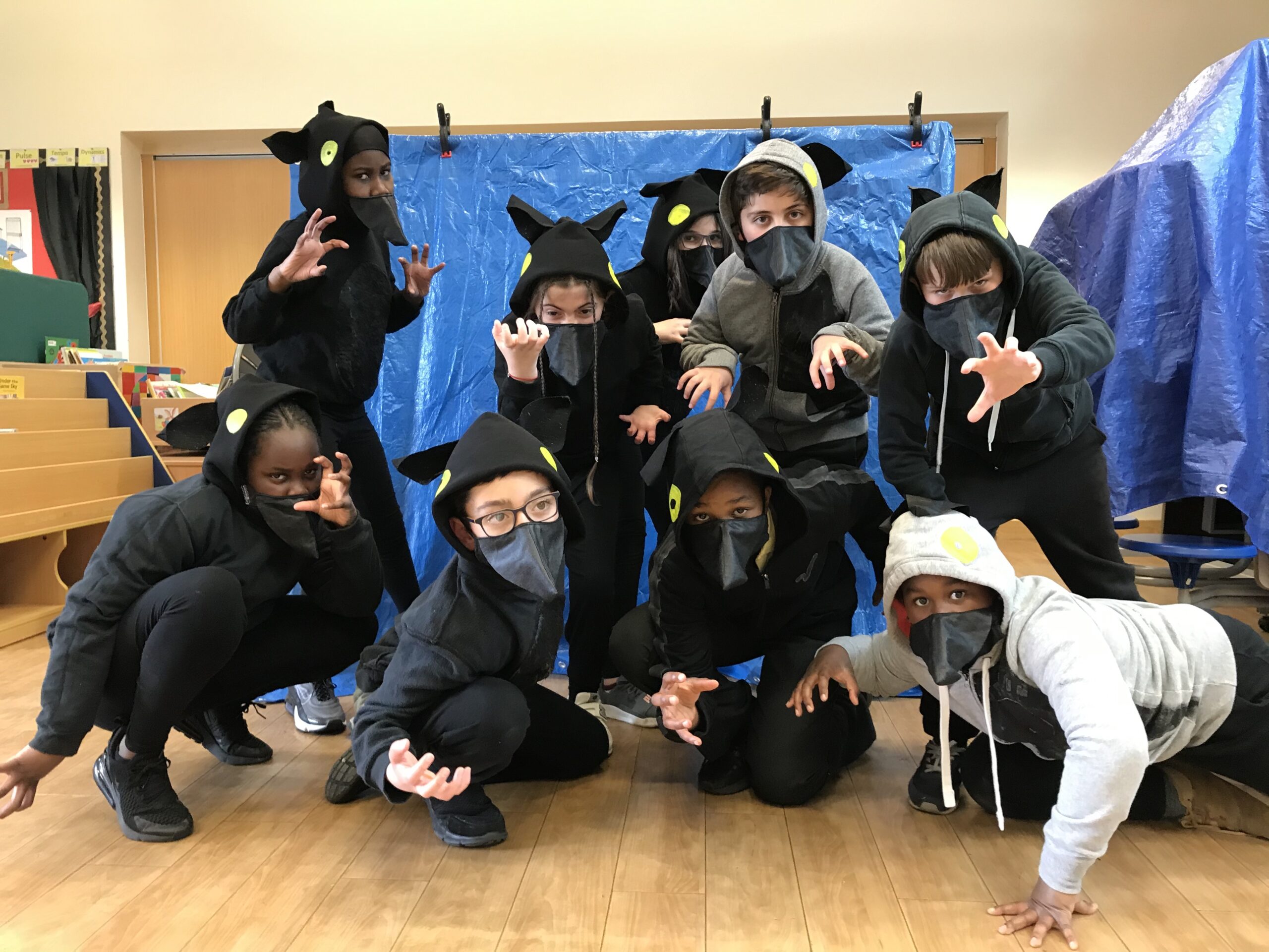 The cast of A Child of Stories: children wearing wolf costumes. Facemasks are part of the costume.