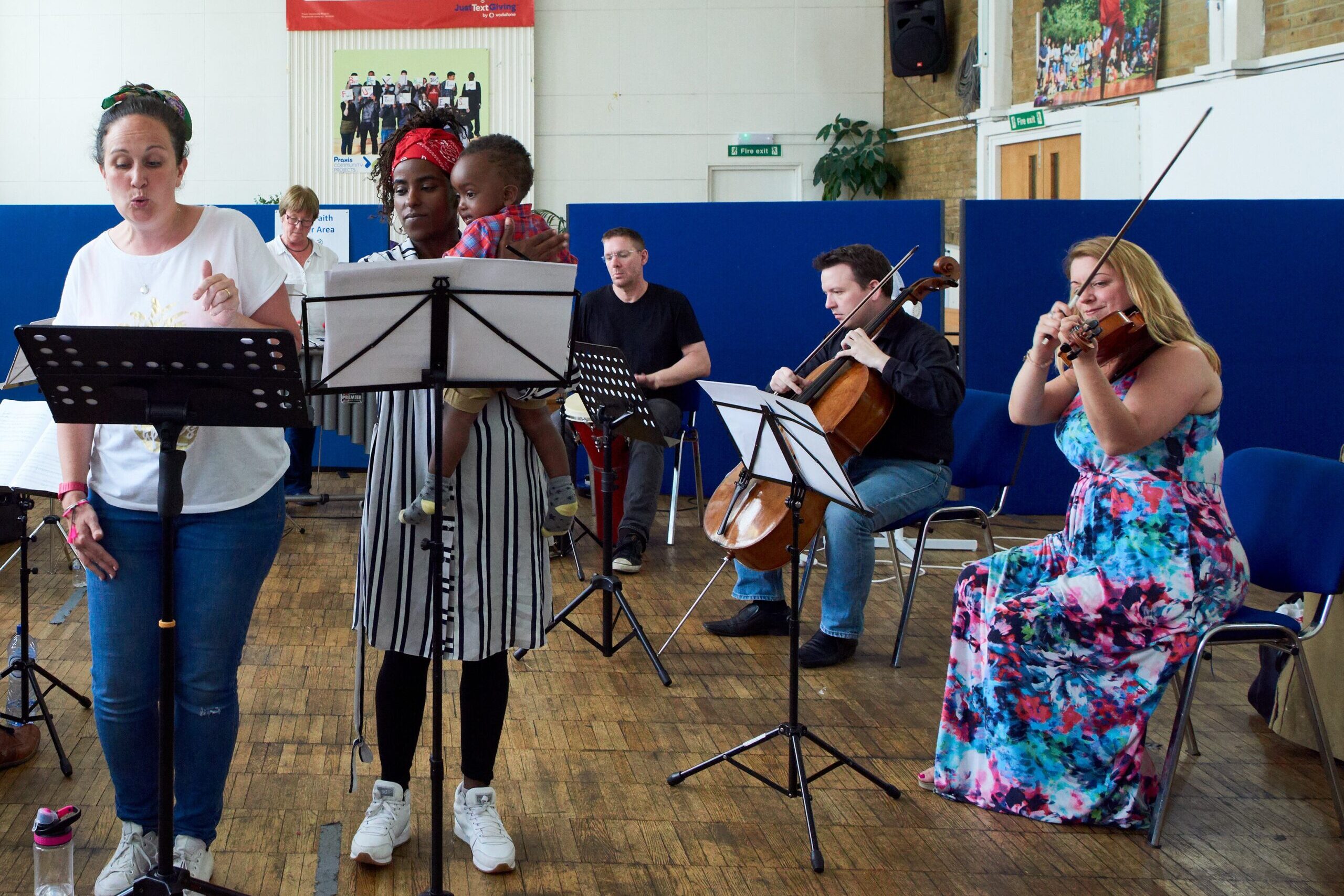 The Amies Freedom Choir during a performance with musicians at Praxis Community Project