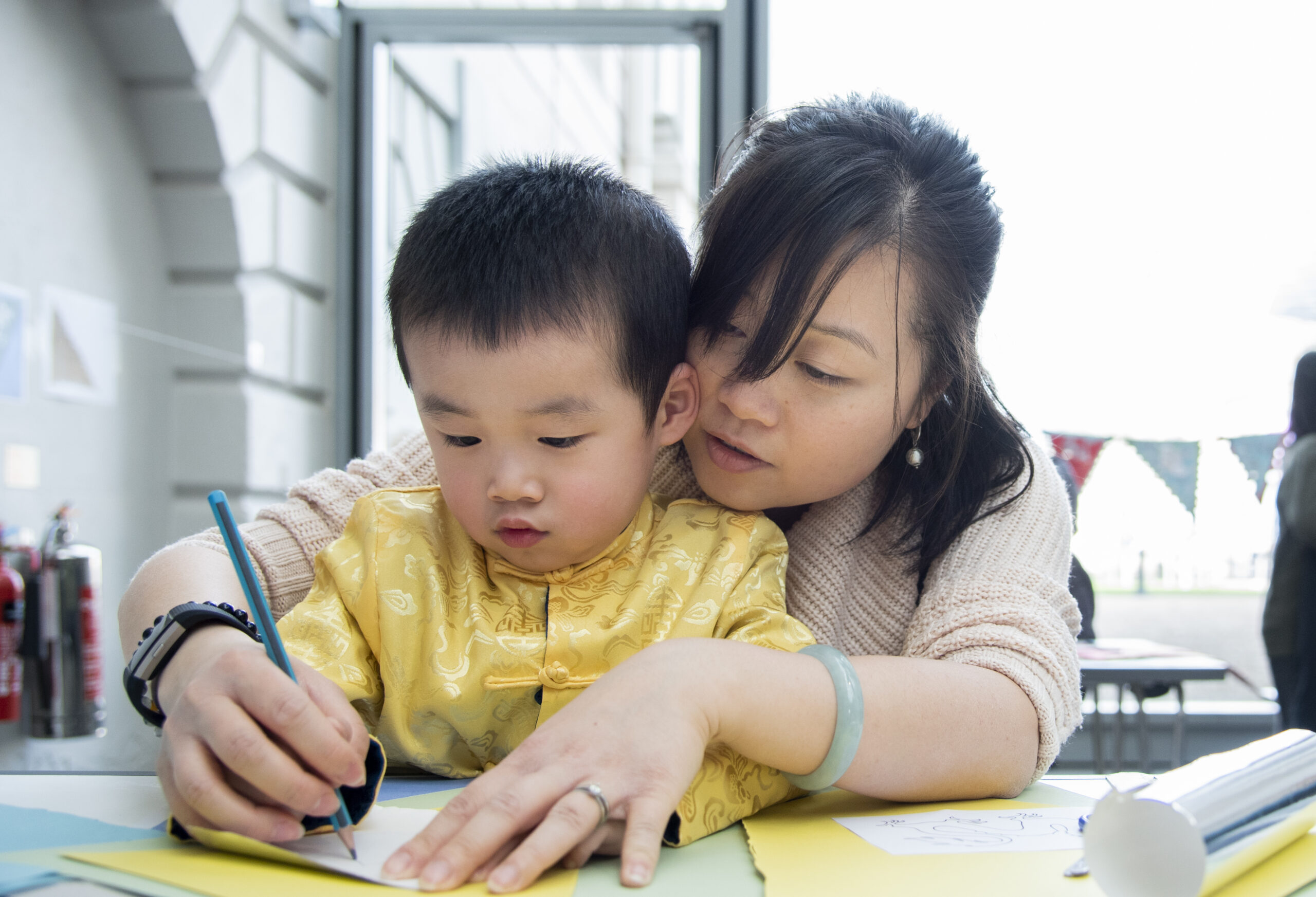 An adult and a child drawing together.